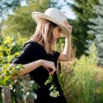 woman in hat in a summertime countryside garden