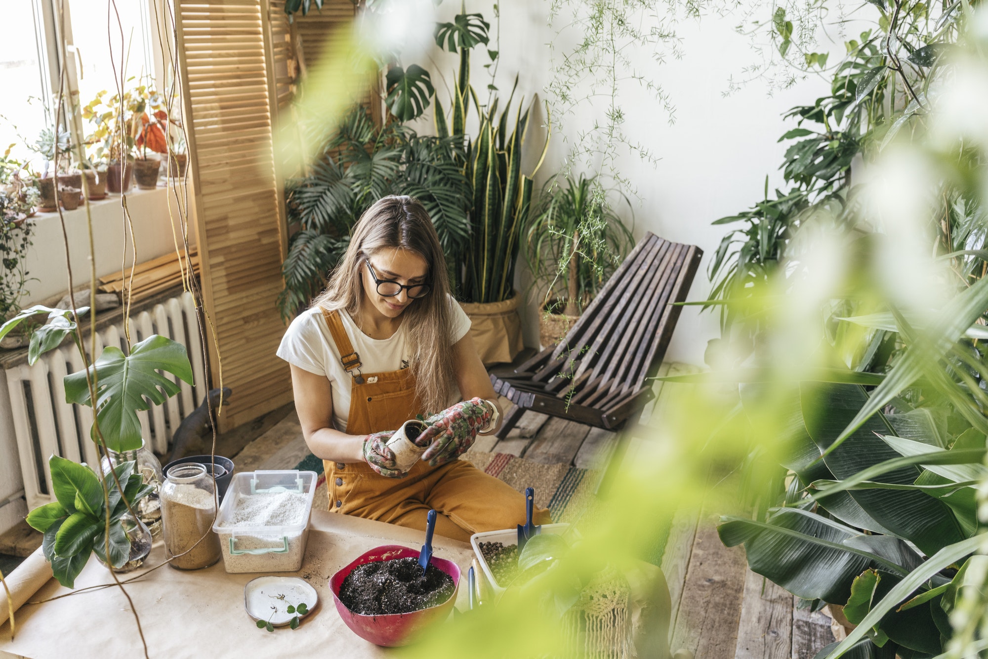 Young woman working with soil in a small gardening shop